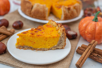 slice of home made pumpkin pie on plate with pumpkins