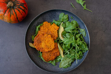 healthy home made pumkin patties with avocado and arugula salad