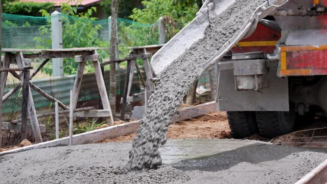 The concrete mix is ​​fed from a concrete mixer. Concreting. Concrete floor in construcktion site