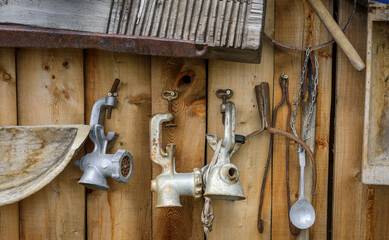 House-museum with old items from traditional rustic life. Vintage meat grinders on the wooden wall. Abstract retro image for the background.