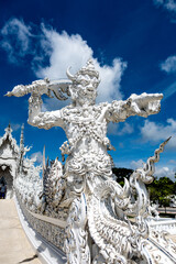 Fototapeta premium Place of worship, Wat Rong Khun also known as the white temple, located in Chiang Rai Province, Thailand. A unique style Buddhist temple with the bridge of “the cycle of rebirth”