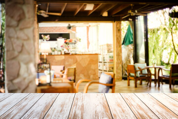 Old style white wooden table in coffee shop blurred background.Warm tones