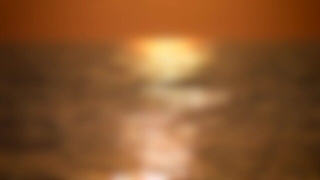 Blurred background. Solar path light on the waves of the sea during sunset,
