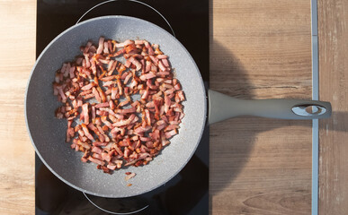 Bacon blocks cooking in frying pan