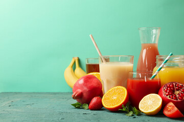 Concept of glasses and bottles with different juices on green background