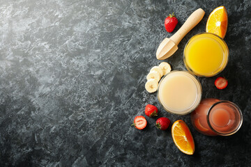 Jars with different juices on smoky dark background