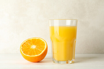 Glass of fresh orange juice on white wooden table