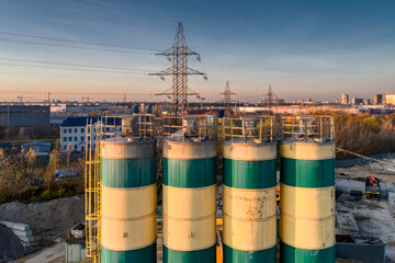 Cement storage silos are painted in yellow-green stripes.