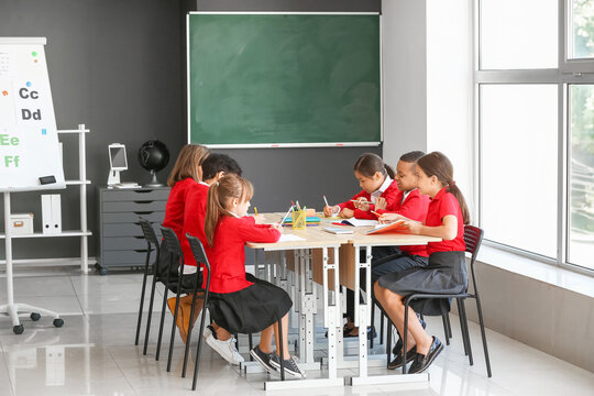Little schoolchildren during lesson in classroom