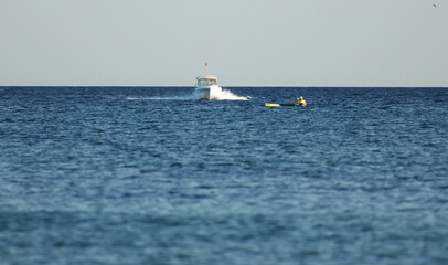 A white yacht on a collision course with a paddler.