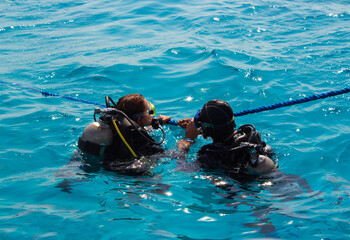 first diving, a girl dives with scuba, snorkel and snorkel with an instructor in the red sea