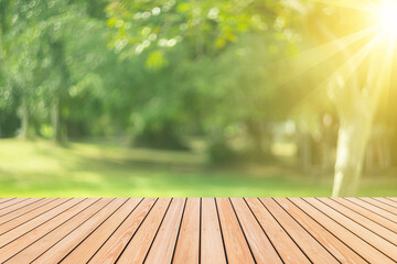 Blur green nature bokeh with sun light on copy space empty old wood table abstract background.