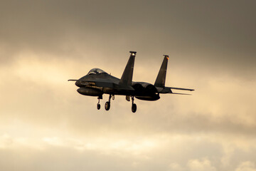 Fototapeta na wymiar Avión de combate F-15 aterrizando al atardecer