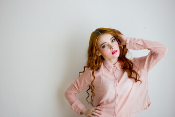 Young woman grimacing on camera at white studio background. Portrait of beautiful girl with ginger lonh hair