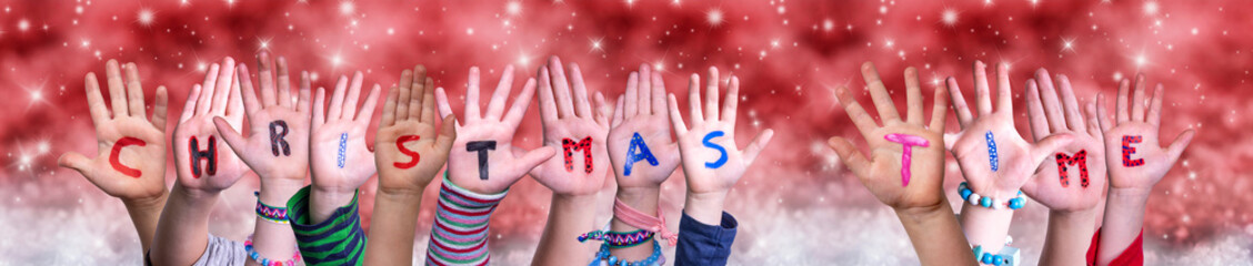 Naklejka premium Children Hands Building Colorful English Word Christmas Time. Red Snowy Christmas Winter Background With Snowflakes And Sparkling Lights