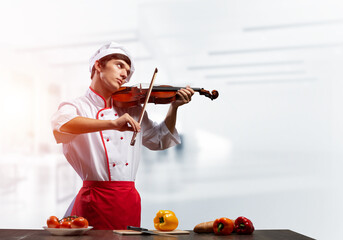 Young male chef with violin standing © adam121