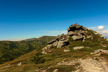 Beautiful landscape with high cliffs and illuminated peaks, blue sky and trails of the Montenegrin ridge, mountain peaks of the Ukrainian Carpathians.