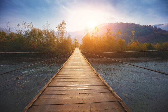 Fototapeta Hanging rope wooden bridge over mountain river
