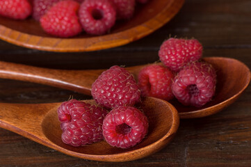background with raspberry close-up. raspberries in a wooden bowl and spoons. raspberry macro.