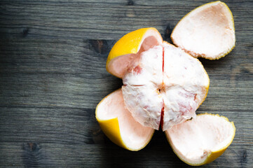 Peeled grapefruit on the dark wooden background