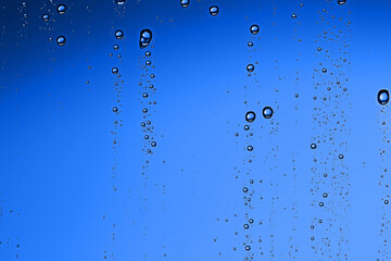 Fototapeta na wymiar fresh drops background blue glass / wet rainy background, water drops transparent glass blue