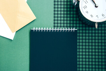 Open spiral notepad with black pages, white and beige envelopes and a beautiful vintage silver...