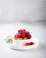 brie or camembert cheese with raspberries, honey, walnutsw and thyme . Selective focus, white background