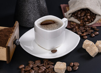 turk and a cup of coffee, sugar, beans on a dark background