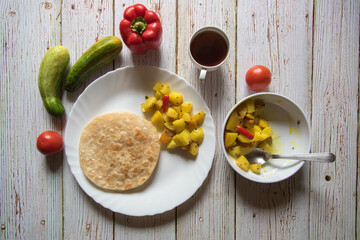 Indian bread puri or paratha with cooked vegetables on a background.