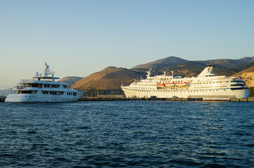 Classic cruiseship or cruise ship liner with motor yacht in port of Kefalonia in Greece during...