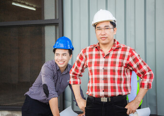 Team of Engineer planning group project partners meeting at building site, Man in hard hat standing and looking at camera at construction site