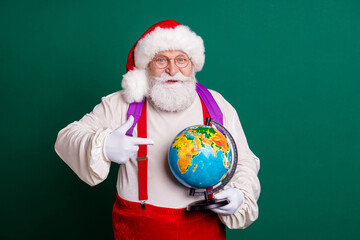 Portrait of his he handsome cheerful bearded smart clever intelligent fat Santa learner holding in hand demonstrating globe country continent ecology lesson isolated green color background
