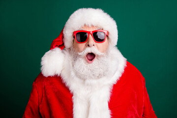 Closeup headshot photo of pensioner old man grey beard open mouth surprised see another man same outwear wear red santa costume coat sun glasses headwear isolated green color background