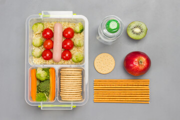 Lunch box with sausage, broccoli and tomatoes. Bottle of water and edible straw