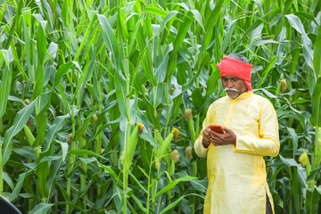 Indian farmer using mobile phone at Agriculture field