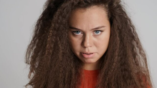 Upset brunette girl dissatisfied with bad treatment angrily looking in camera isolated on white background