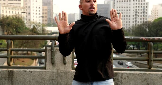 Dancer mimic comedian leaning on imaginary wall in downtown street performance
