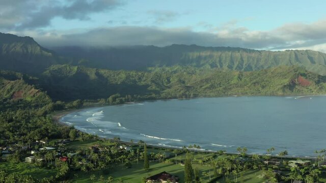 Hanalei Bay Kauai Hawaii. Circling aerial drone shot. Overview of ocean and homes on beautiful sunny morning
