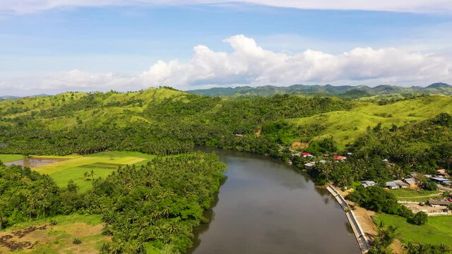 Tropical landscape in sunny weather. Village by the river. Green hills and river. Summer and travel vacation concept. The nature of the Philippine Islands, Samar
