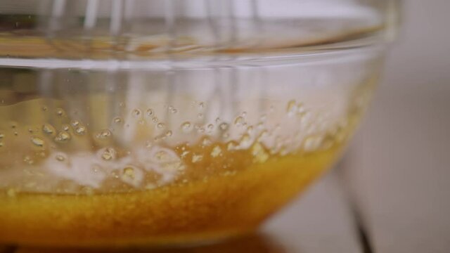 Mixing Olive Oil And Bottarga Fish Roe In A Glass Bowl With A Whisk - Bottarga Spaghetti Recipe - extreme close up, slow motion