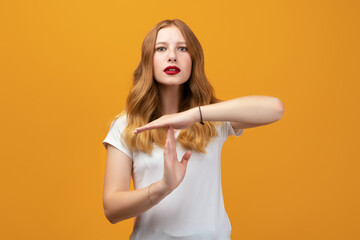 Pretty Young woman Doing time-out gesture with hands, frustrated and serious face. Studio shot,...