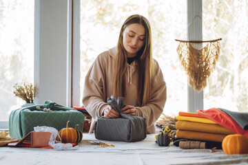 Woman wraps Furoshiki gift in zero waste style. Furoshiki Japanese Gift Wrapping. Thanksgiving Zero...