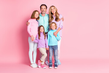 Full size photo of harmony idyllic big full family with mommy daddy three kids older younger siblings little boy girl hug embrace enjoy togetherness isolated over pink color background