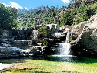 waterfall in valley with natural pool