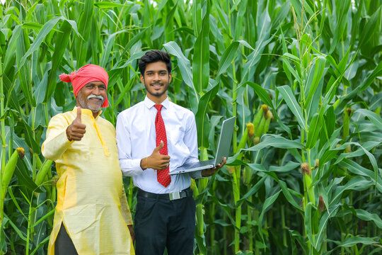 Indian Farmer With Agronomist At Corn Field And Showing Some Information In Laptop