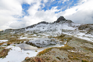 Fototapeta na wymiar Mountain landscape in early autumn with the first snow near a small pond