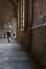 Fototapeta na wymiar Turista cruzando un pasillo de la Catedral de Oviedo 