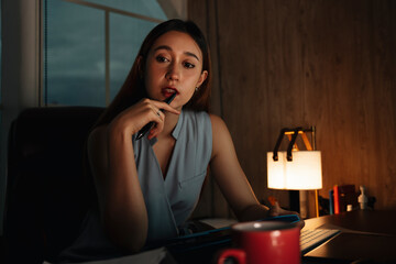 Beautiful businesswoman working overtime in office at night.