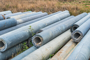Stack of concrete pipes at a construction site outdoors warehouse. Civil infrastructure, industry manufacturing of cement products