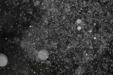 Silver bokeh defocus dark abstract background. Silver festive Christmas lights. Glitter twinkled...